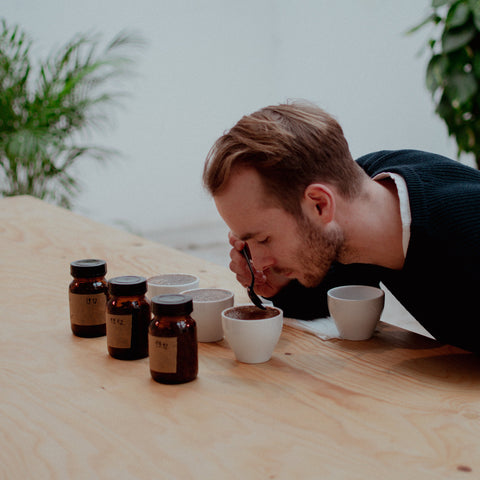 Eine Person riecht an einem Kaffee in einem Cupping in der zwoo kaffeeschule im kaffee-atelier in Köln.